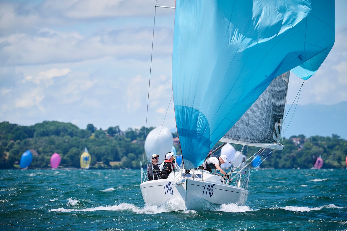 Voilier J/92s sous gennaker bleu pendant la régate du Bol d'Or sur le Lac Léman — vue dynamique de la coque blanche fendant l'eau.